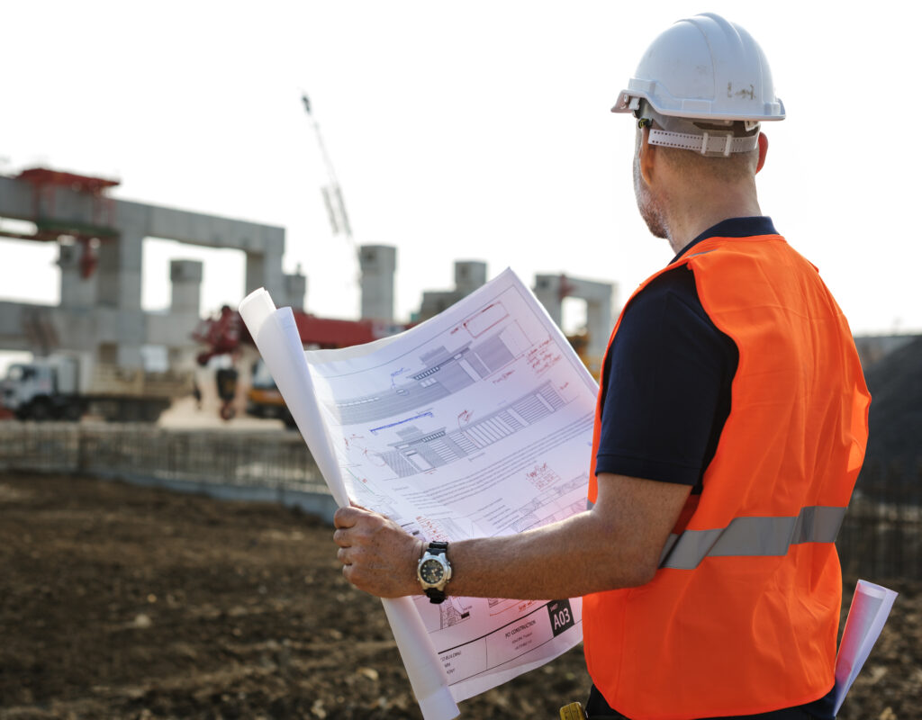 Civil engineering contractor reviewing blueprints on a small construction site